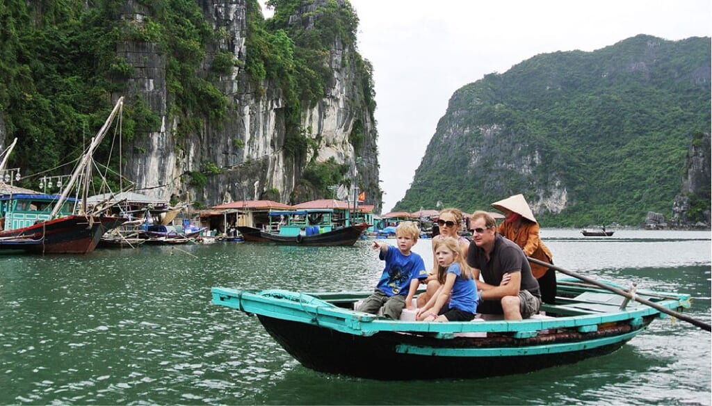 Bamboo boat ride past a floating village in Halong Bay