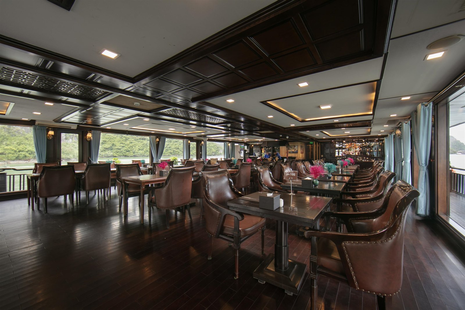 Restaurant with wooden interiors and bay-view windows aboard Mila Grand Cruises