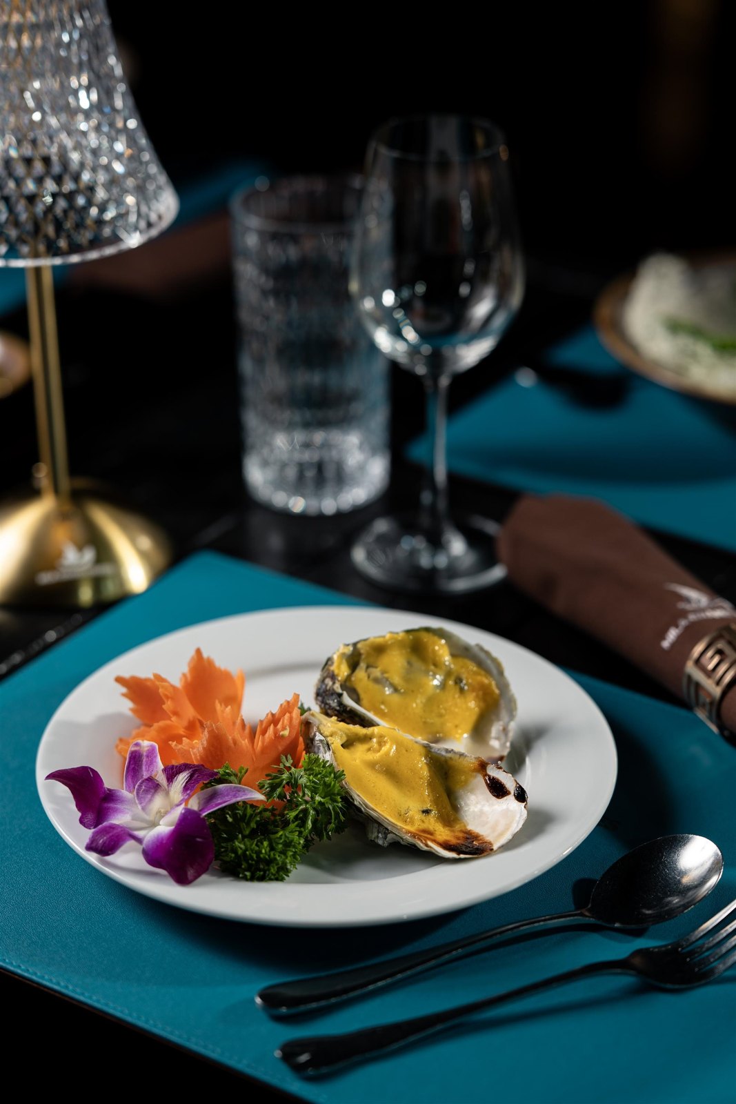 Plated main course at a candle-lit dinner table aboard Mila Grand Cruises
